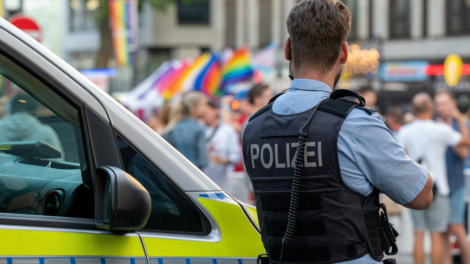 Ein Polizist beobachtet das CSD-Straßenfest.