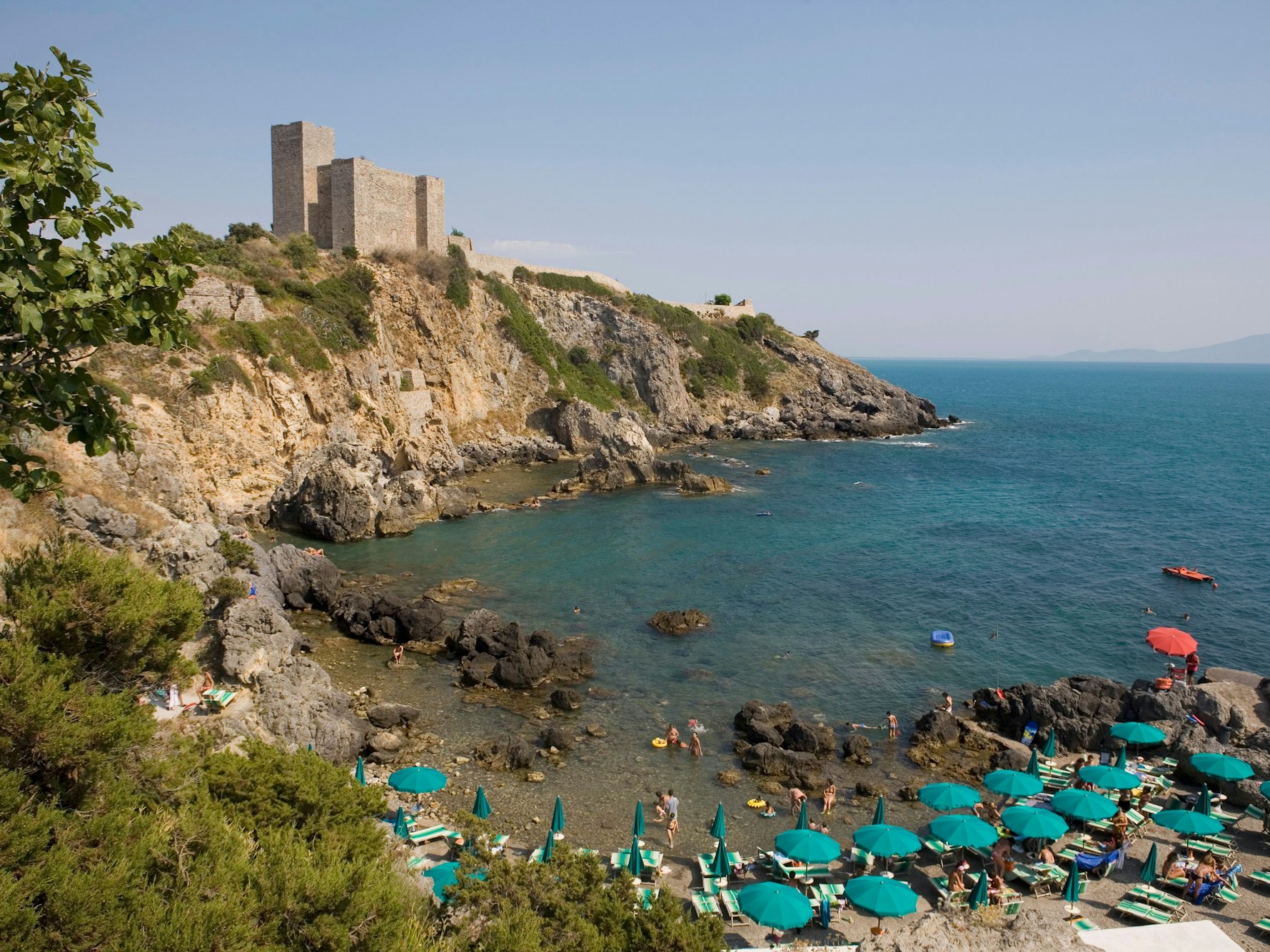 Sonnenschirme und Sonnenliegen am Strand von Bagno delle Donne in Talamone in der Toskana in Italien.