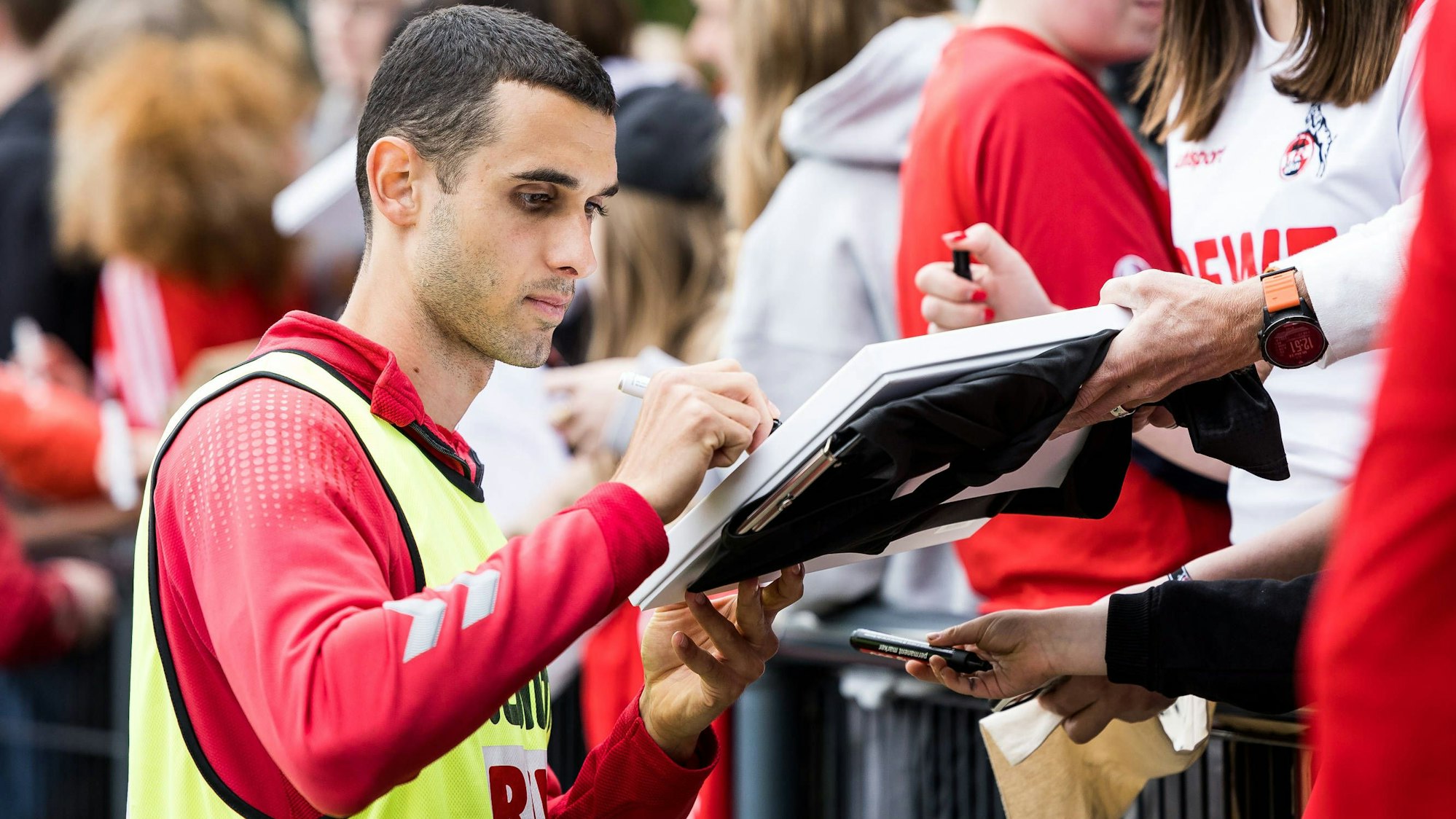 Ellyes Skhiri schreibt nach einem FC-Training Autogramme.