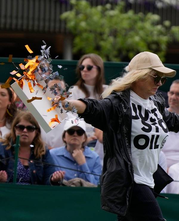 Eine Klimaaktivistin verteilt auf Court 18 in Wimbledon Konfetti-Schnipsel und Puzzle-Teile.