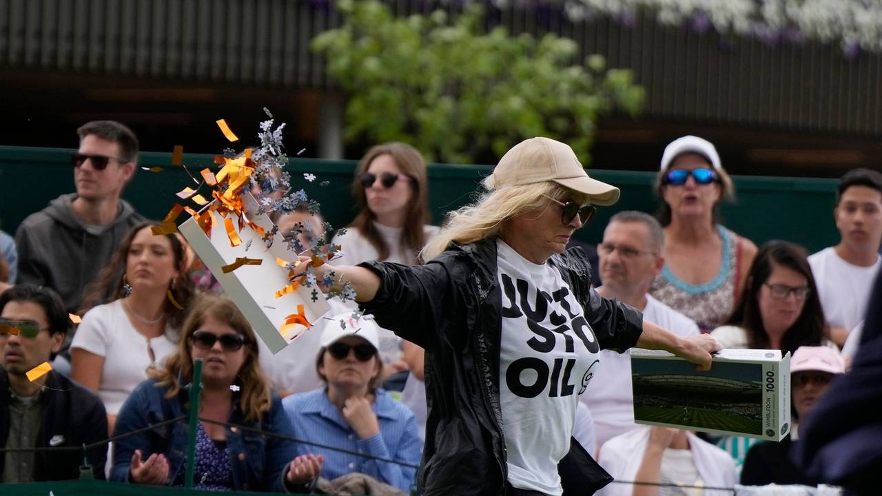Eine Klimaaktivistin verteilt auf Court 18 in Wimbledon Konfetti-Schnipsel und Puzzle-Teile.