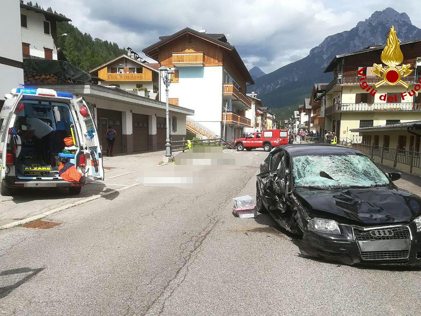 Ein Krankenwagen und das Auto der Deutschen stehen nach dem Unfall neben den Opfern (gepixelt), die auf einer Straße liegen.