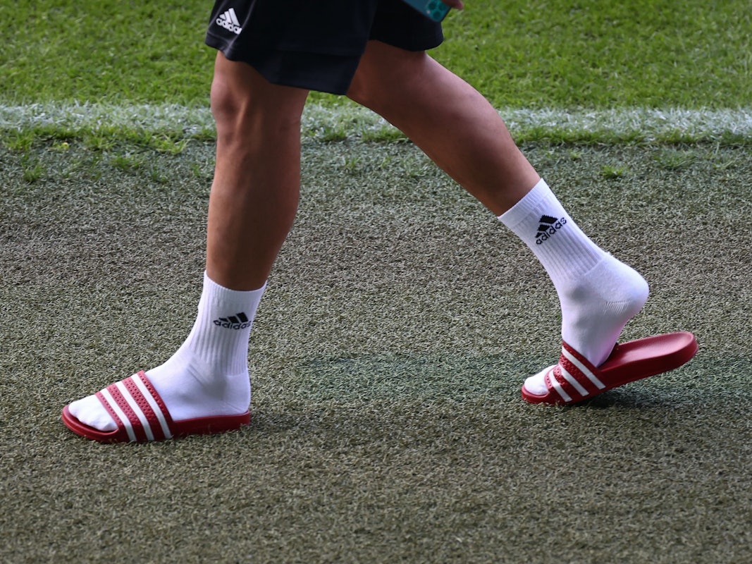 Fußball: Nationalmannschaft, Deutschland, Abschlusstraining im Stadion St. Jakob-Park. Leroy Sane kommt mit Adiletten zu einem Interview vor dem Abschlusstraining ins Stadion. +++ dpa-Bildfunk +++