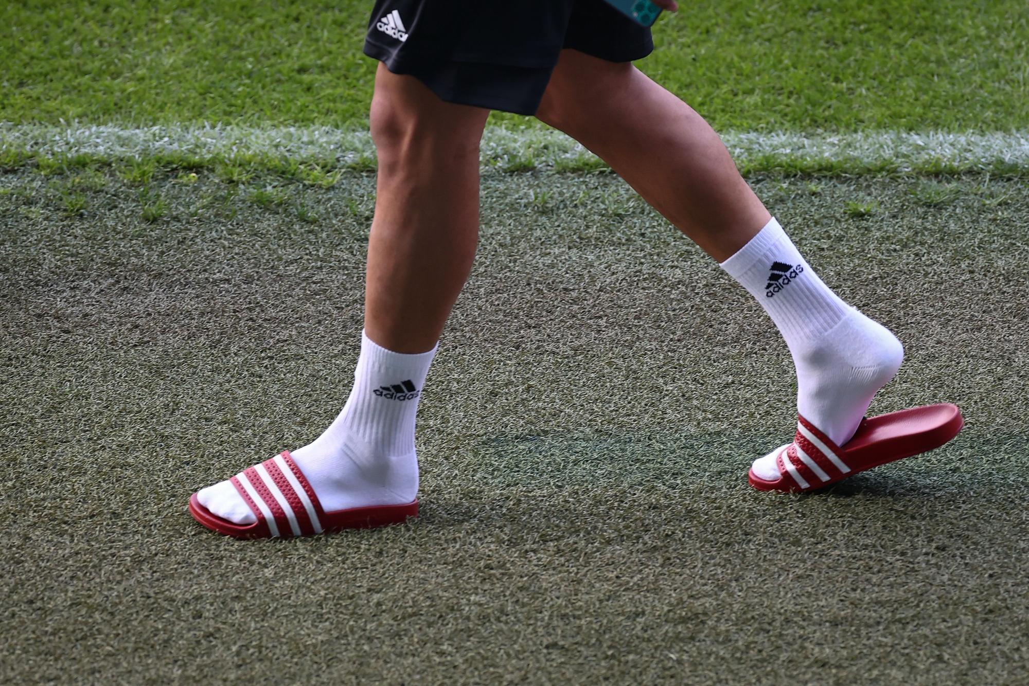 Fußball: Nationalmannschaft, Deutschland, Abschlusstraining im Stadion St. Jakob-Park. Leroy Sane kommt mit Adiletten zu einem Interview vor dem Abschlusstraining ins Stadion. +++ dpa-Bildfunk +++