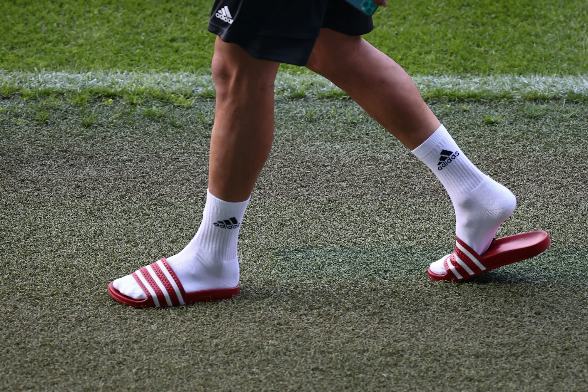 Fußball: Nationalmannschaft, Deutschland, Abschlusstraining im Stadion St. Jakob-Park. Leroy Sane kommt mit Adiletten zu einem Interview vor dem Abschlusstraining ins Stadion. +++ dpa-Bildfunk +++