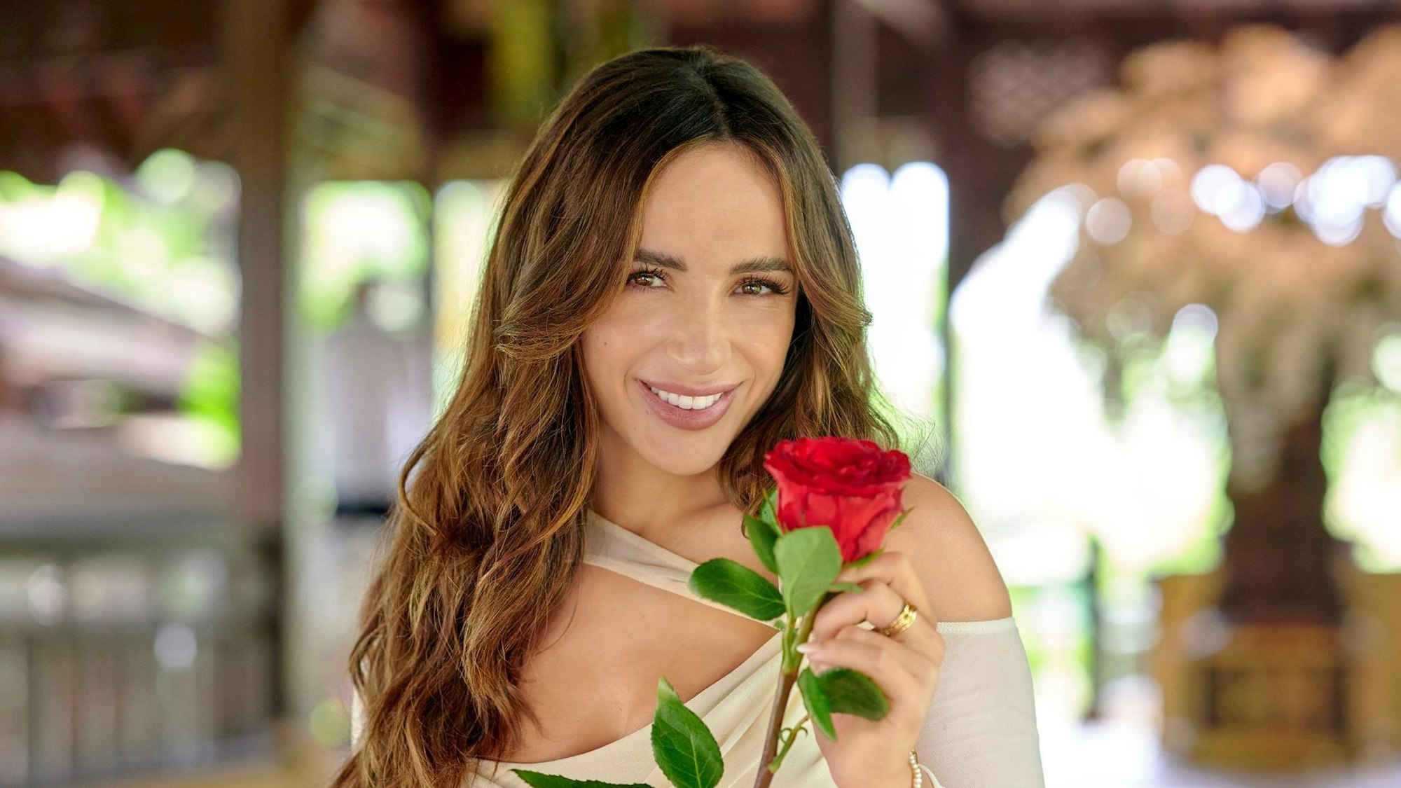 Jennifer Saro hält eine Rose.