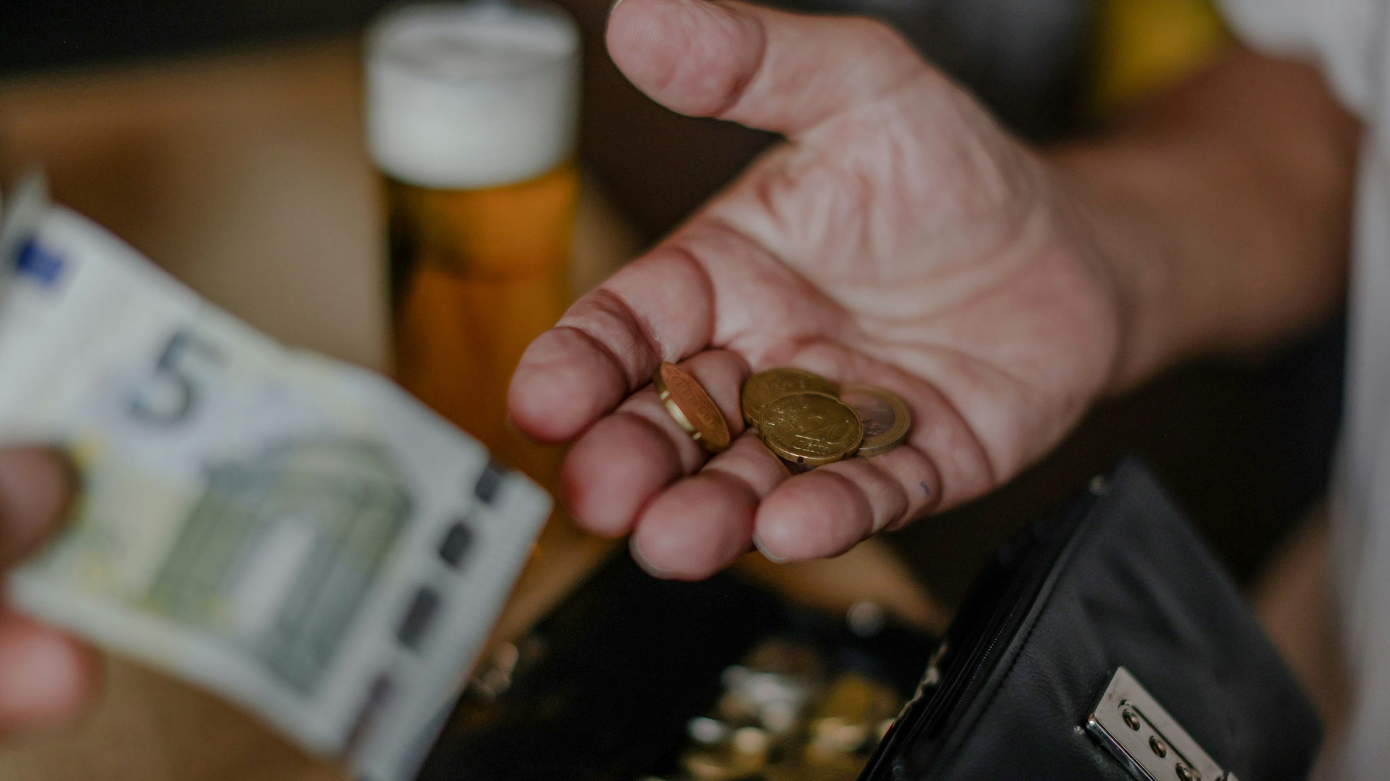 Kölsch wird mit einem Fünf-Euro-Schein bezahlt.