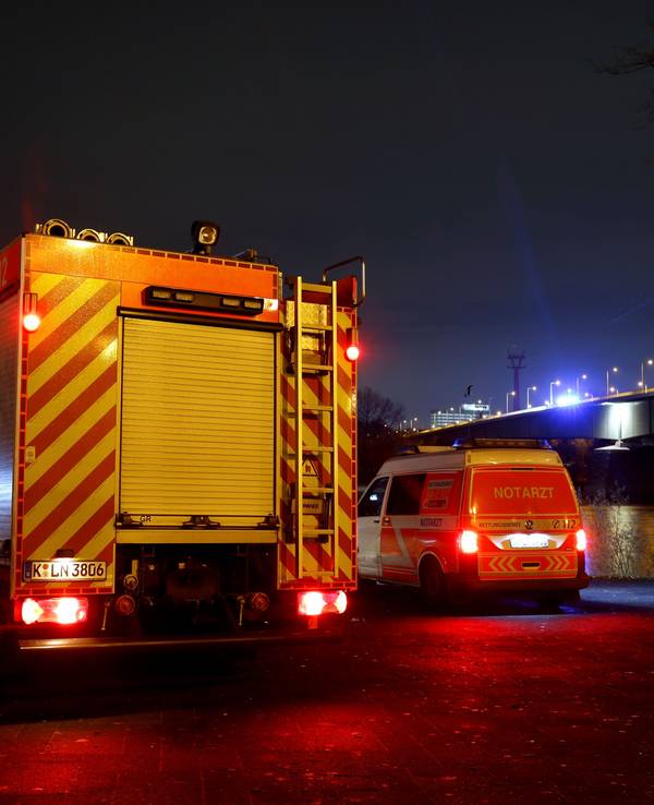 Ein Löschfahrzeug und ein zweites Einsatzfahrzeug stehen in der Nacht unterhalb einer Brücke.