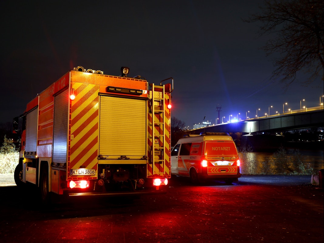 Ein Löschfahrzeug und ein zweites Einsatzfahrzeug stehen in der Nacht unterhalb einer Brücke.