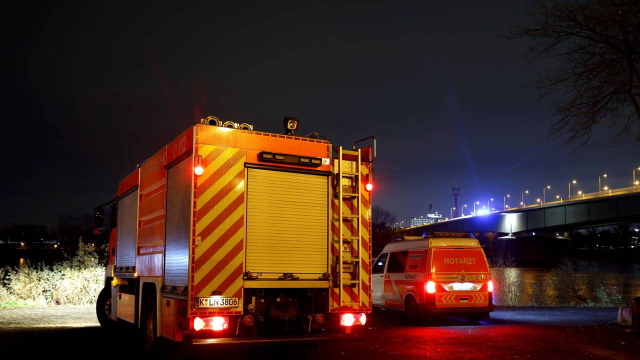 Ein Löschfahrzeug und ein zweites Einsatzfahrzeug stehen in der Nacht unterhalb einer Brücke.