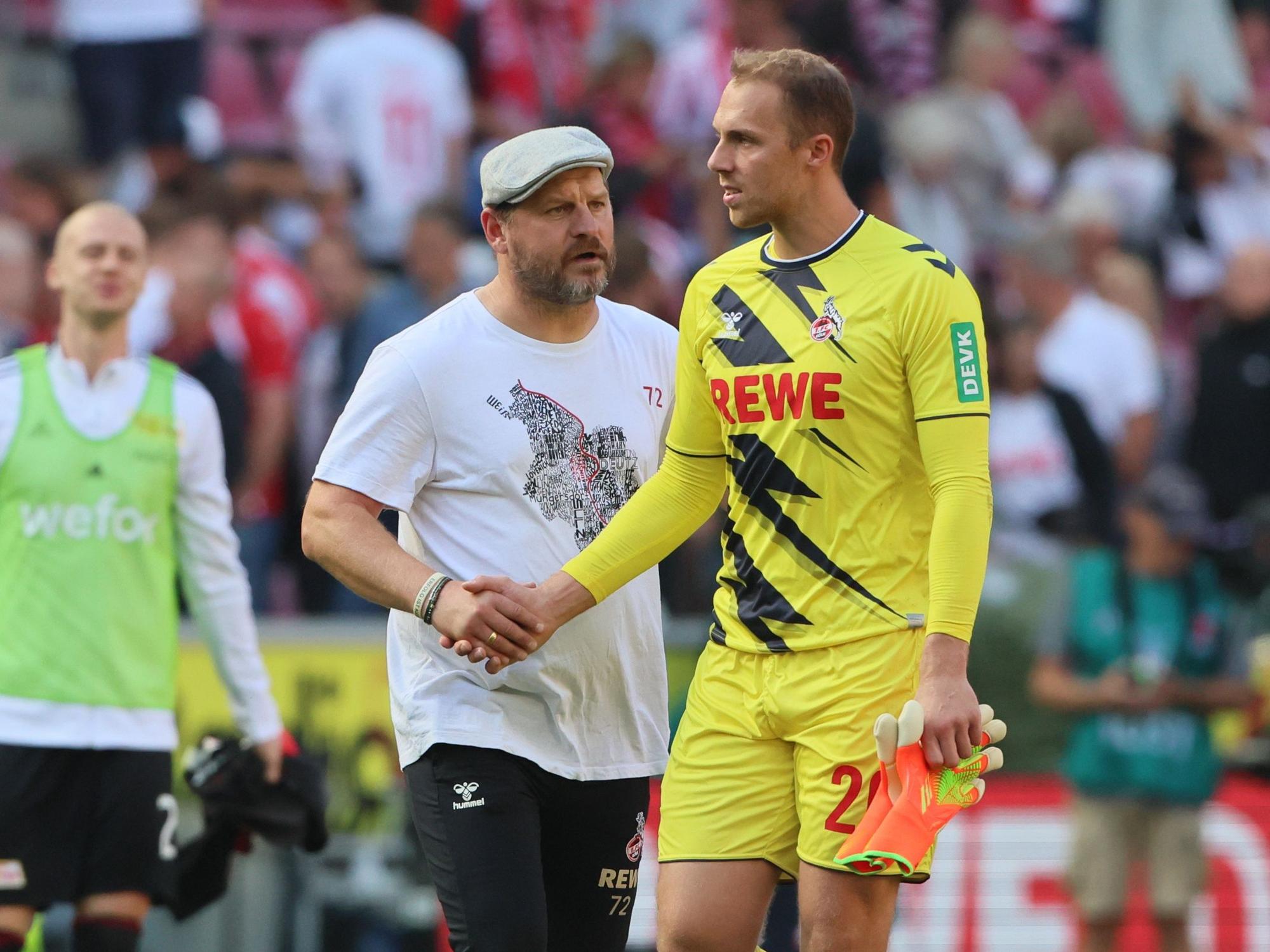 Steffen Baumgart spricht mit Marvin Schwäbe auf dem Platz und gibt ihm die Hand.