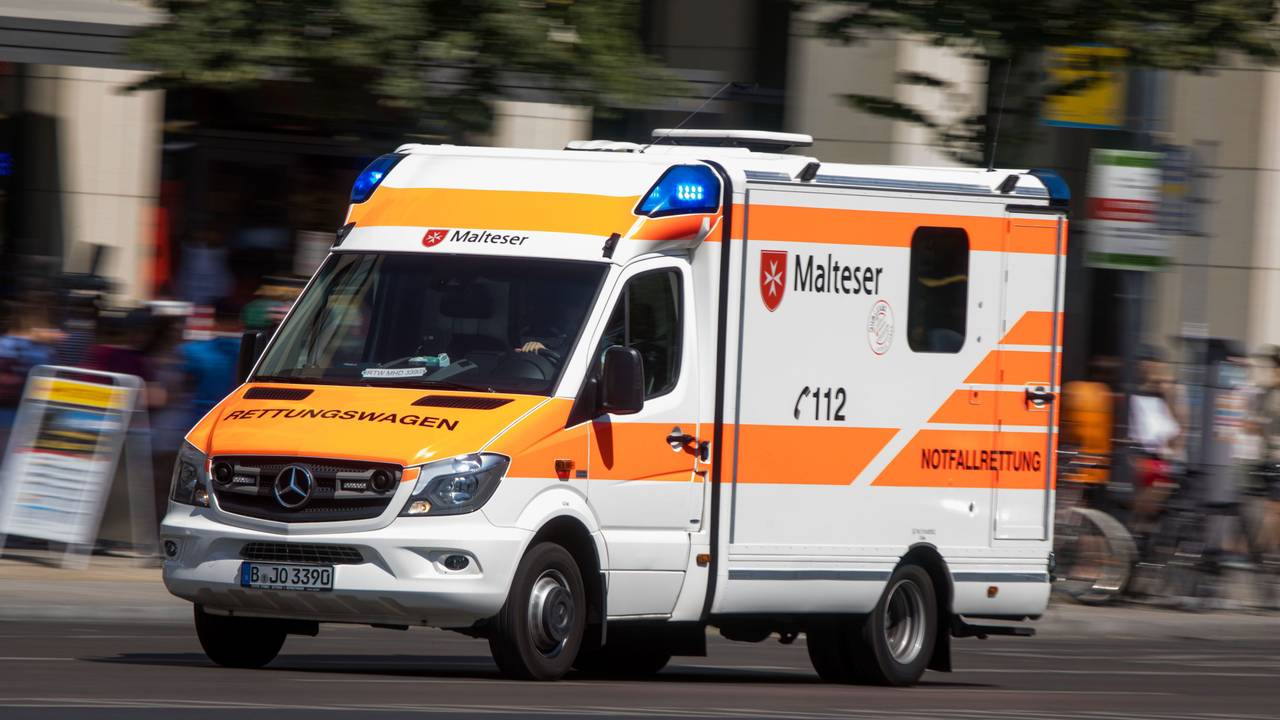 Rettungswagen mit Blaulicht auf einer Straße.