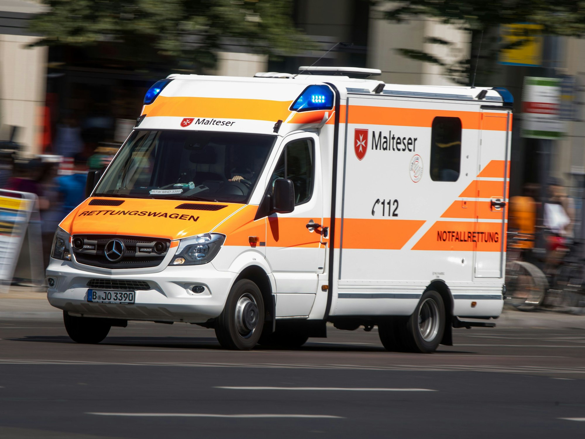 Rettungswagen mit Blaulicht auf einer Straße.