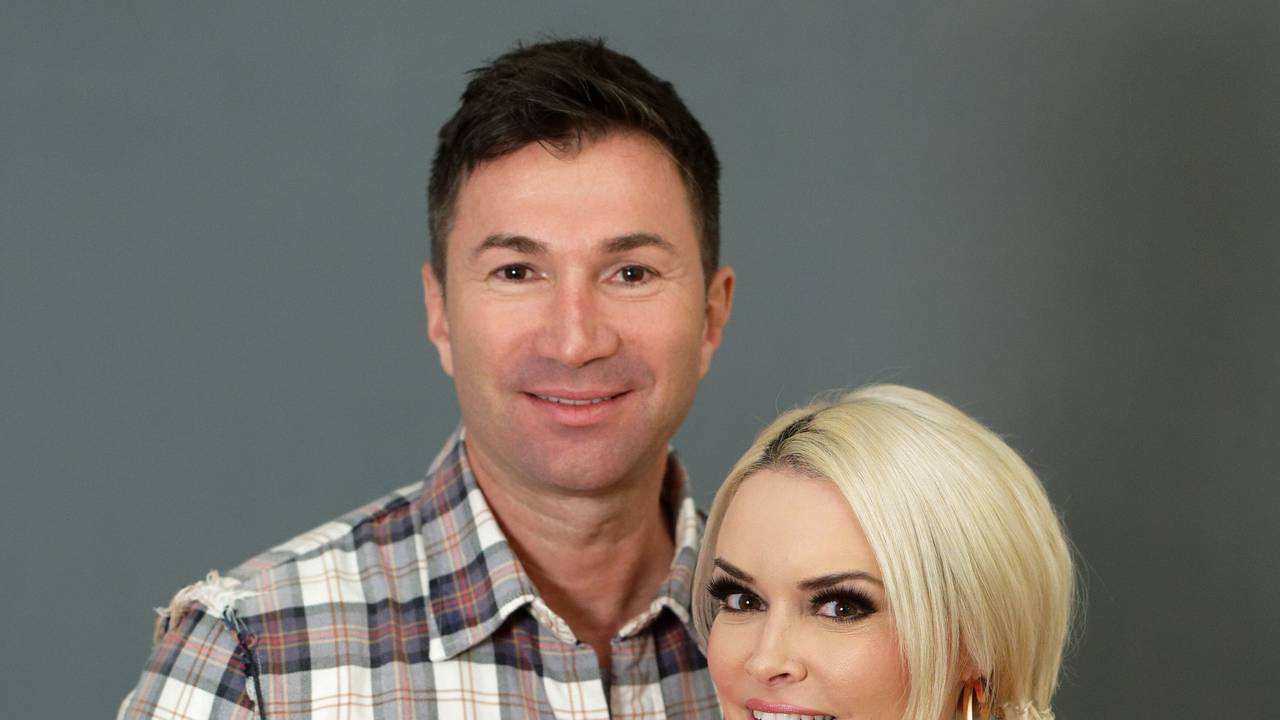 Reality-Show-Darstellerin Daniela Katzenberger und und ihr Ehemann, der Sänger Lucas Cordalis, stehen bei einem Fototermin vor einer grauen Wand. Lucas Cordalis hat dabei die Arme um seine Frau geschlungen.