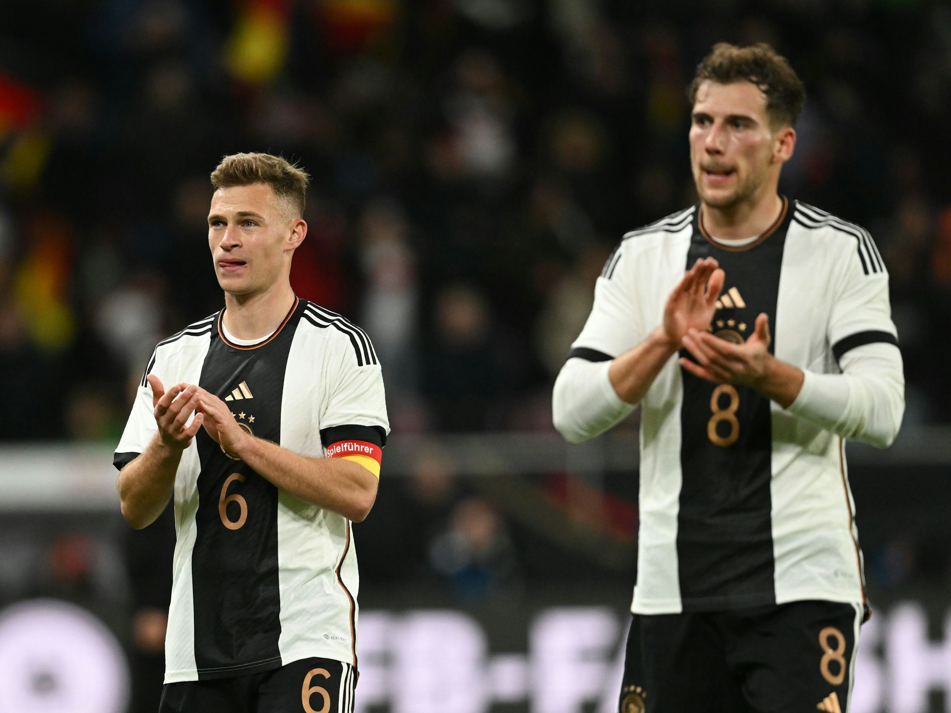 Die deutschen Nationalspieler Joshua Kimmich (l.) und Leon Goretzka apllaudieren ihren Fans.
