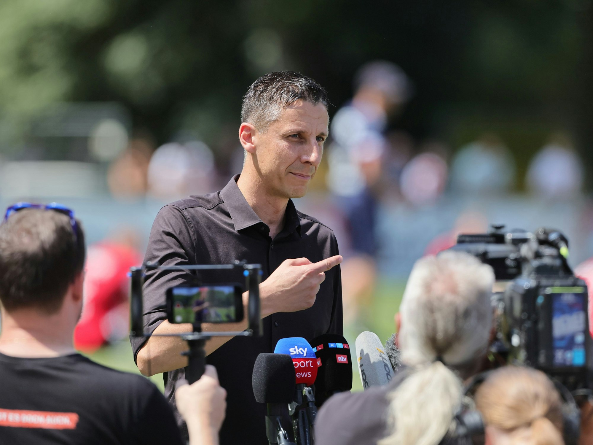 Christian Keller vor Kameras und Mikrofonen.