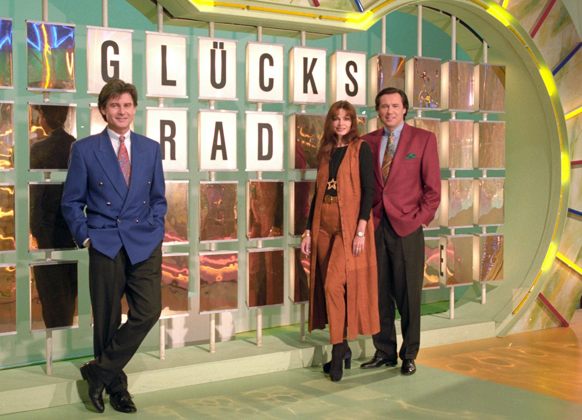 Das Sat1 «Glücksrad»-Team mit Frederic Meisner (l), Maren Gilzer und Peter Bond stehen am 10.02.1994 im Sat.1-Studio vor der Buchstaben-Rätselwand