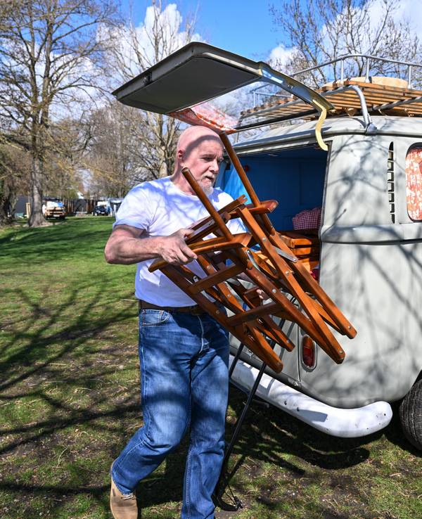 Camper Uwe aus Freiburg holt am 10. April 2022 einen Campingstuhl aus seinem VW-Bulli (T2), den er unmittelbar am Ufer des Bodensees geparkt hat.