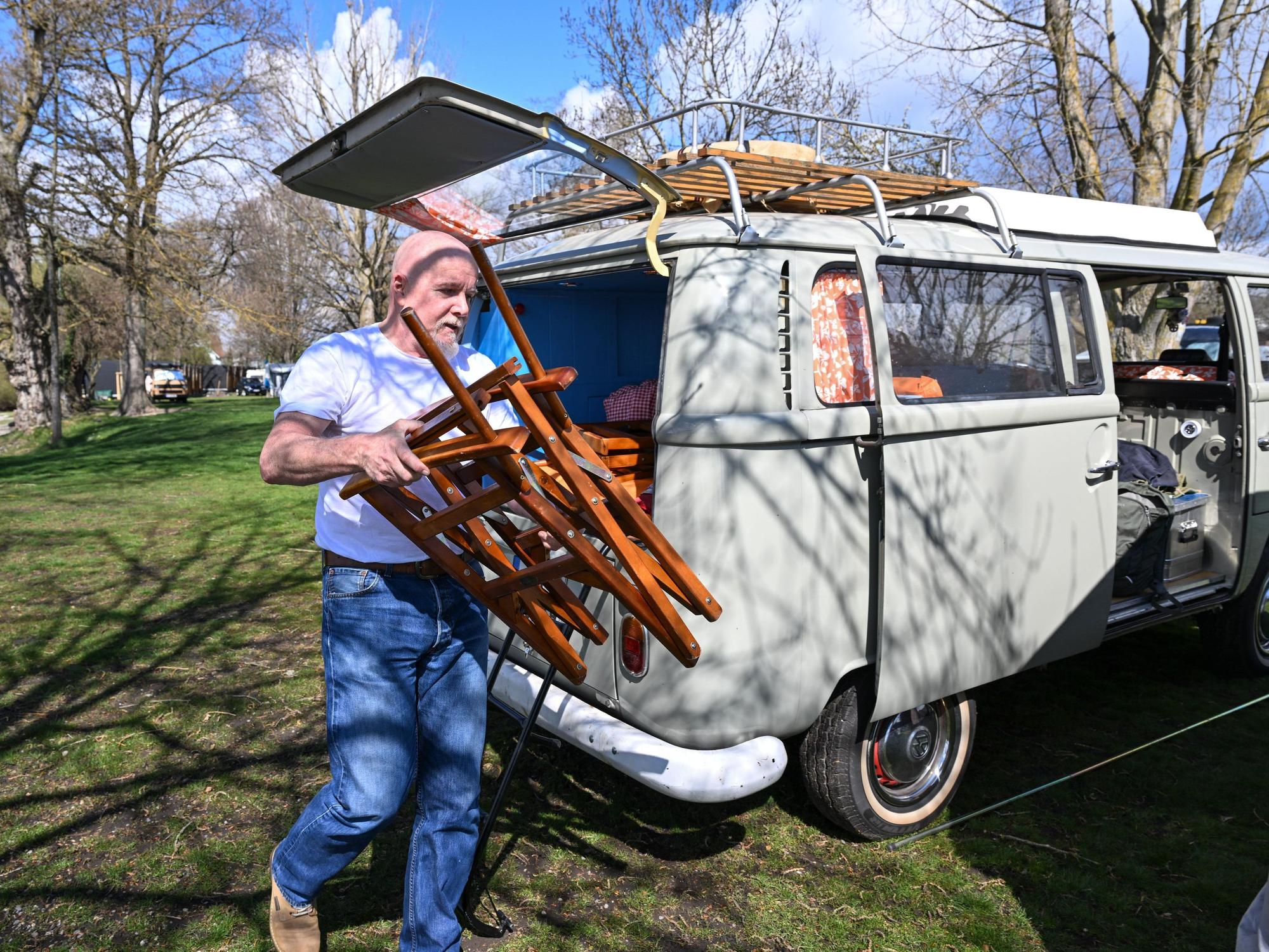 Camper Uwe aus Freiburg holt am 10. April 2022 einen Campingstuhl aus seinem VW-Bulli (T2), den er unmittelbar am Ufer des Bodensees geparkt hat.