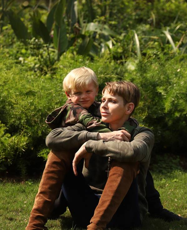 Fürstin Charlène von Monaco und ihr Sohn Jacques sitzen in einem Garten.