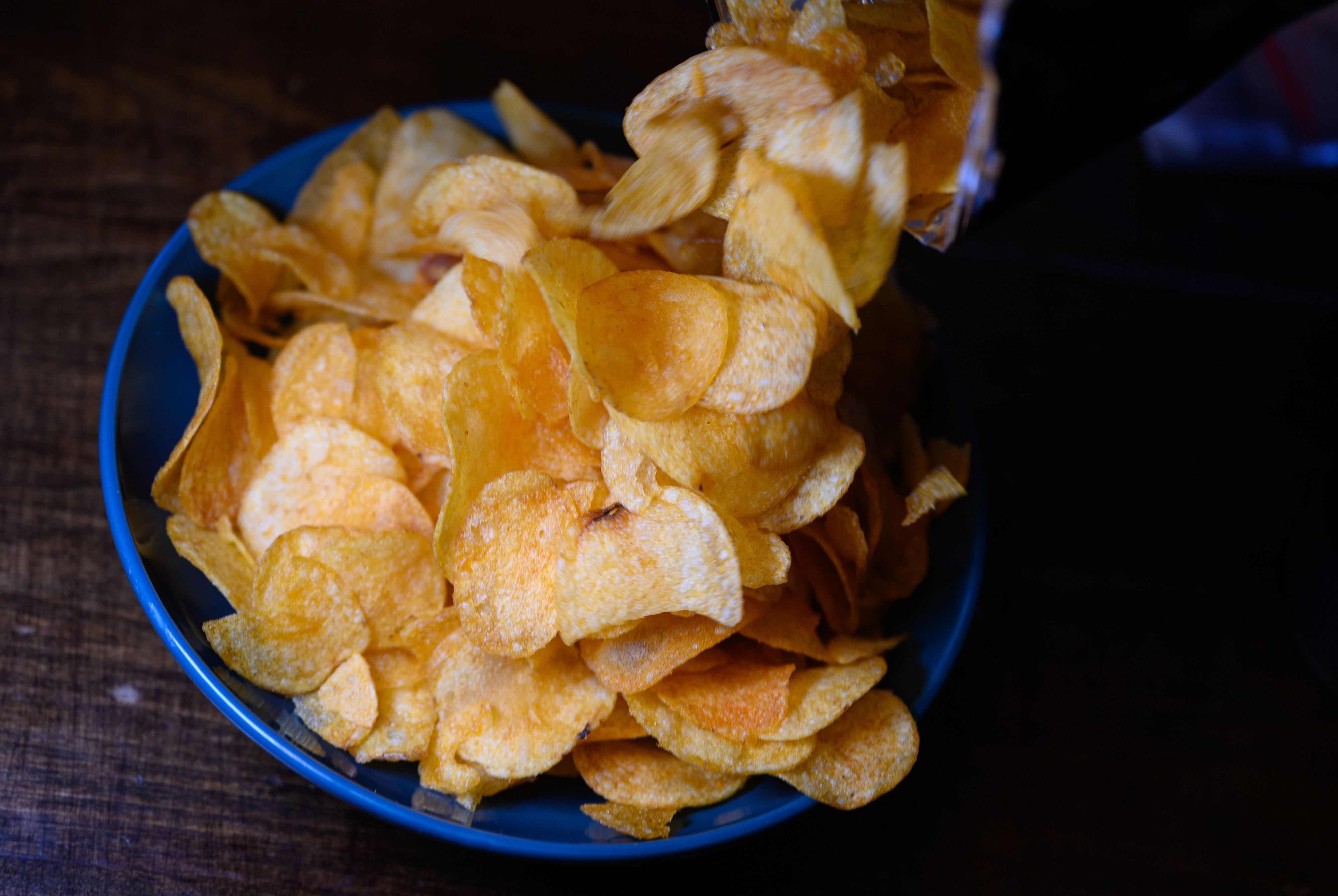 Eine Schüssel mit Kartoffelchips steht auf einem Tisch.