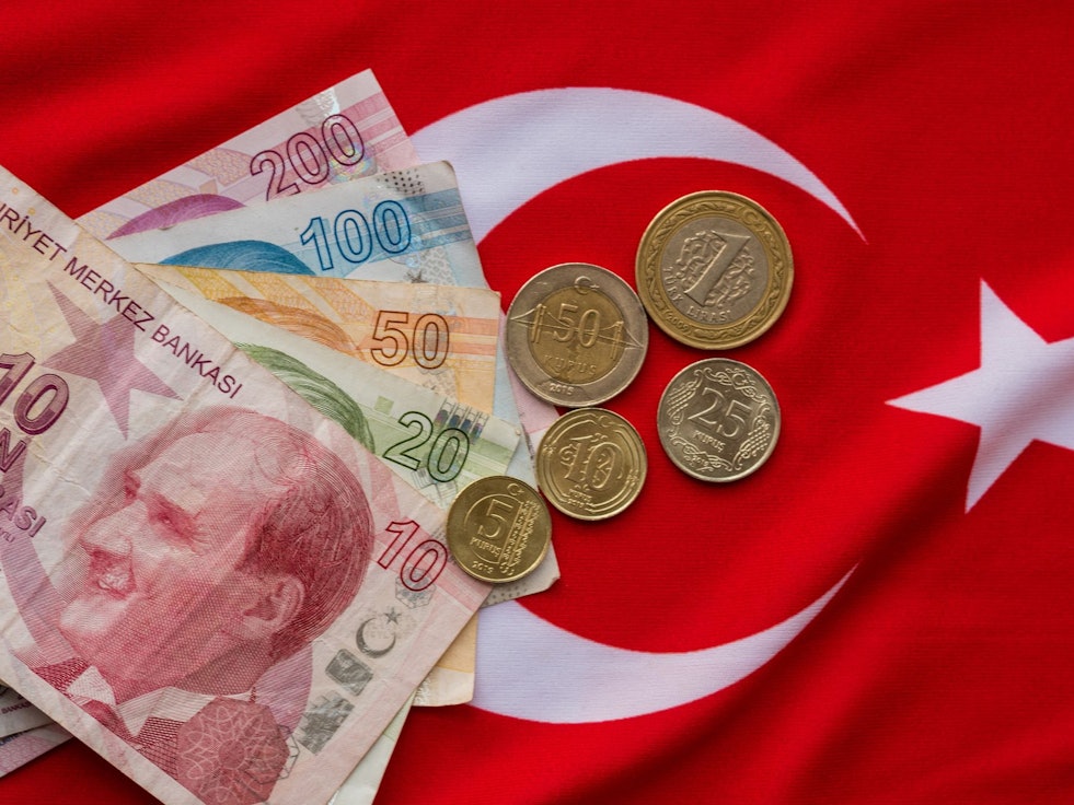Türkische Lira liegen auf einer Türkeiflagge.
