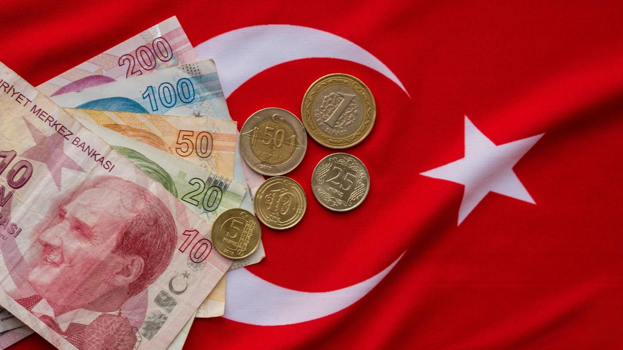 Türkische Lira liegen auf einer Türkeiflagge.