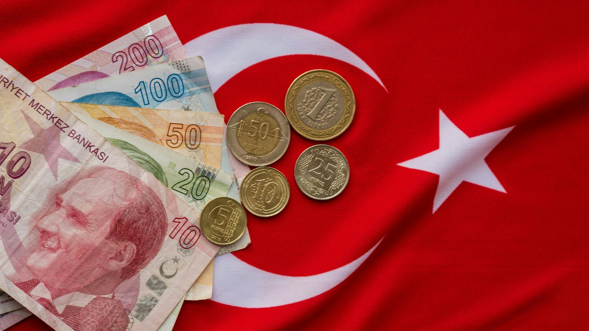 Türkische Lira liegen auf einer Türkeiflagge.