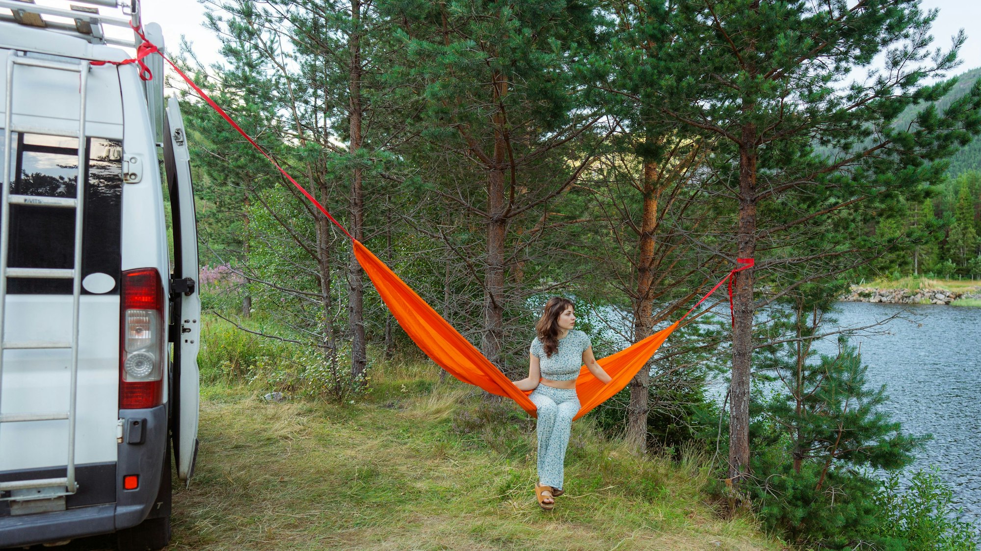 Junge Frau mit Camper und Hängematte
