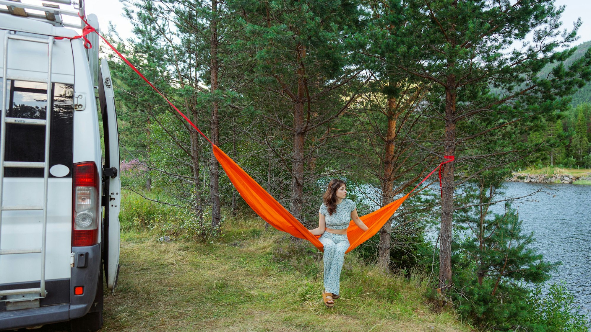 Junge Frau mit Camper und Hängematte