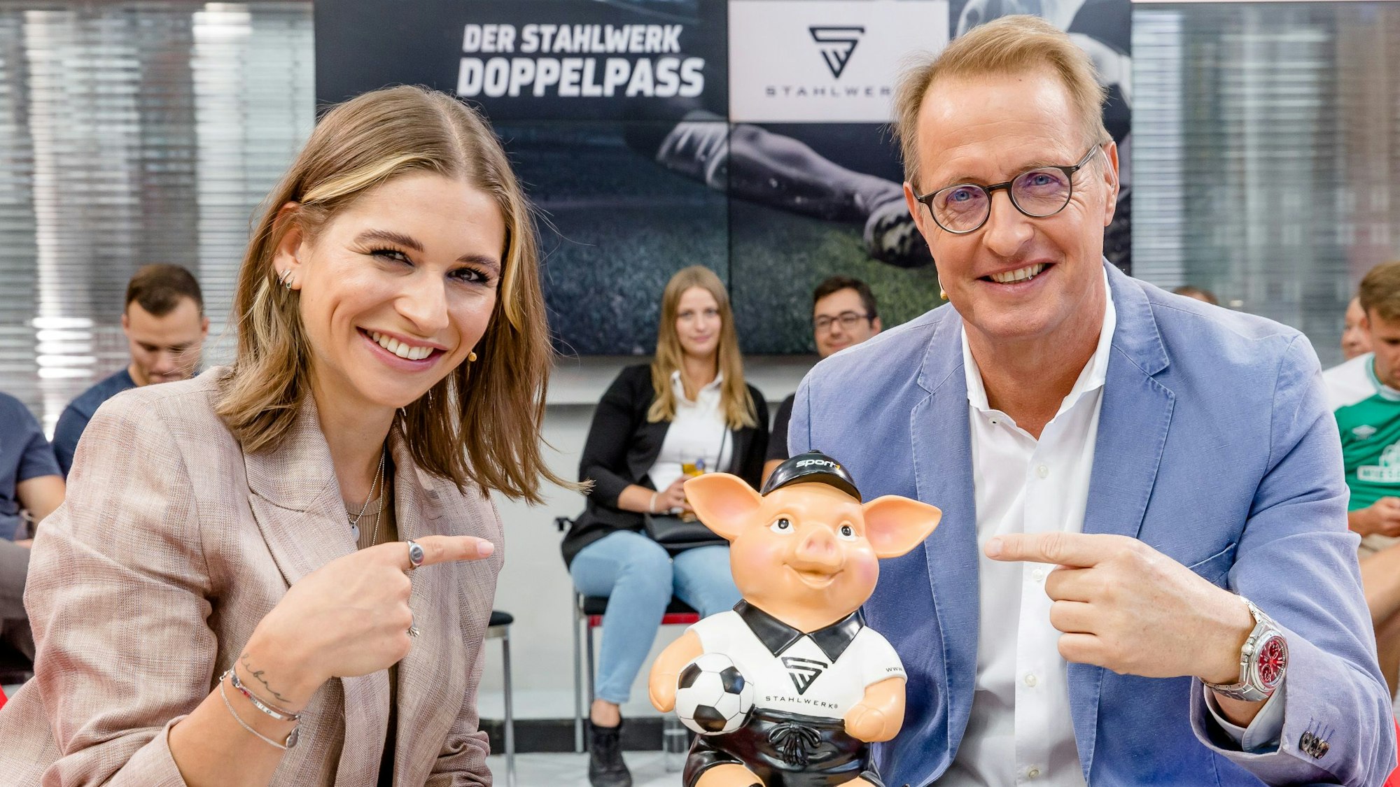 Jana Wosnitza und Florian König posieren mit dem Phrasenschwein beim „Doppelpass“.