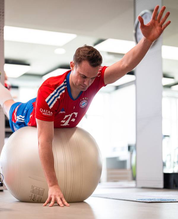 Manuel Neuer liegt mit dem Bauch auf einem Gymnastik-Ball und streckt die Gliedmaßen von sich.