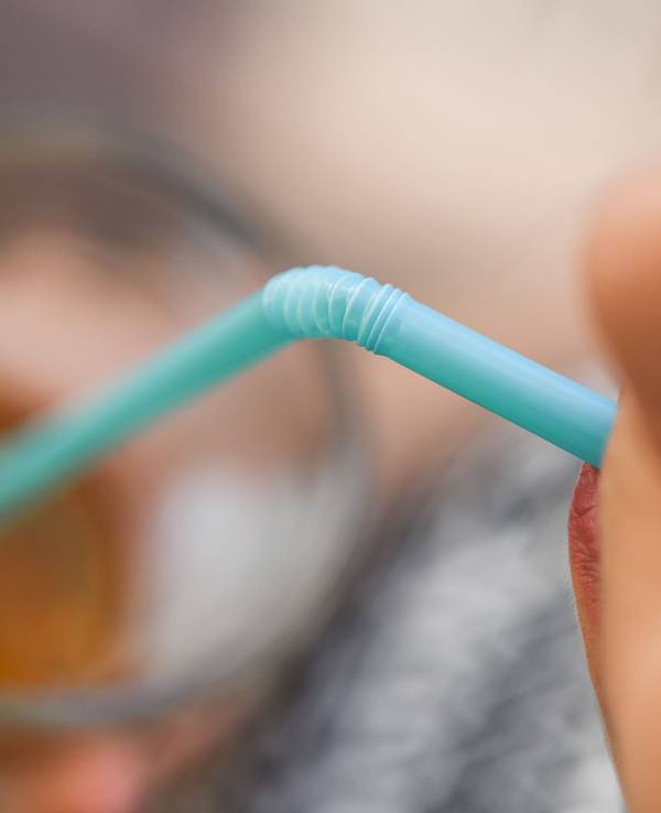 Ein Mädchen trinkt mit einem Strohhalm aus Plastik aus einem Glas, hier im Mai 2018.