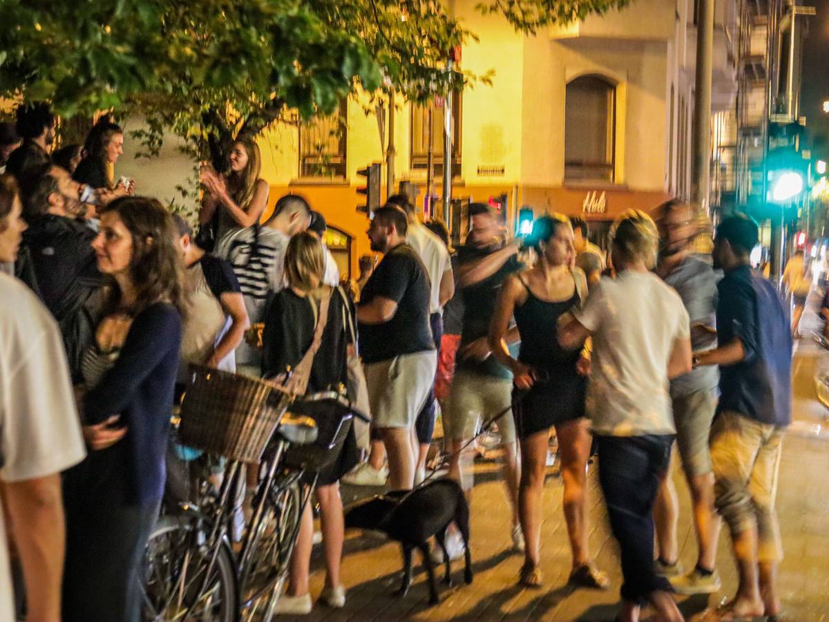 Menschen stehen auf der Venloer Straße in Köln und genießen das Nachtleben.