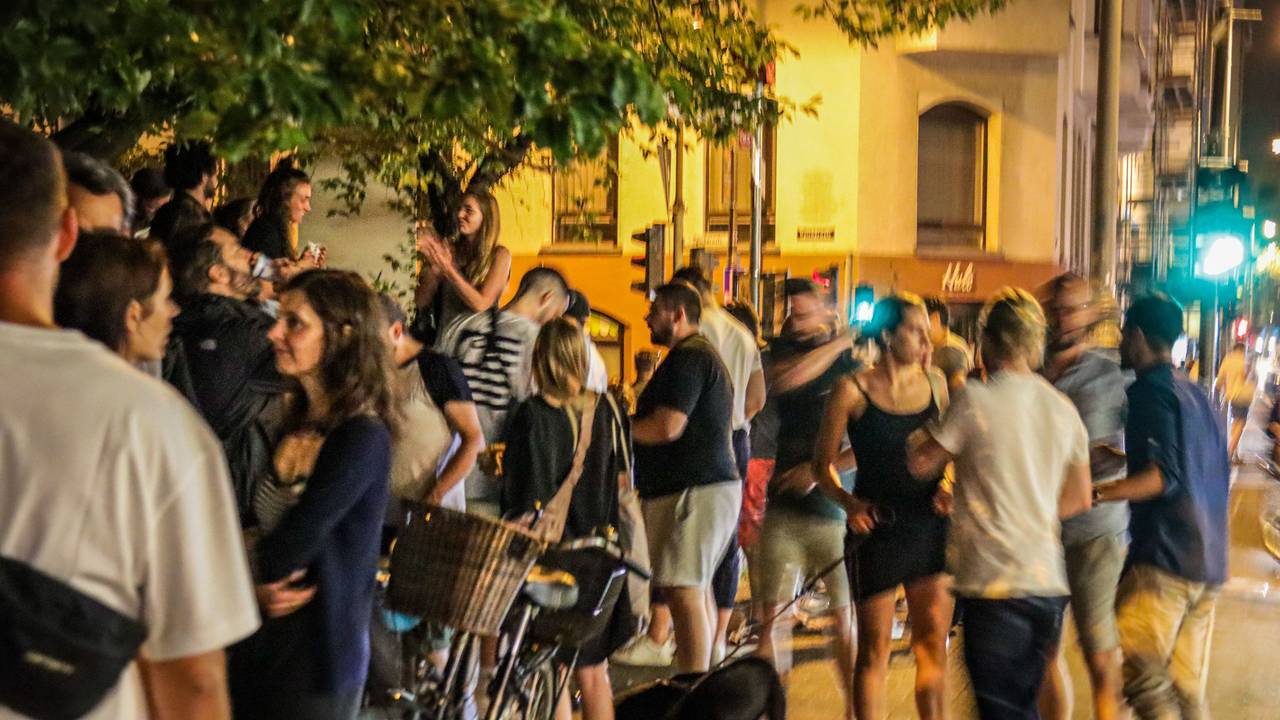 Menschen stehen auf der Venloer Straße in Köln und genießen das Nachtleben.