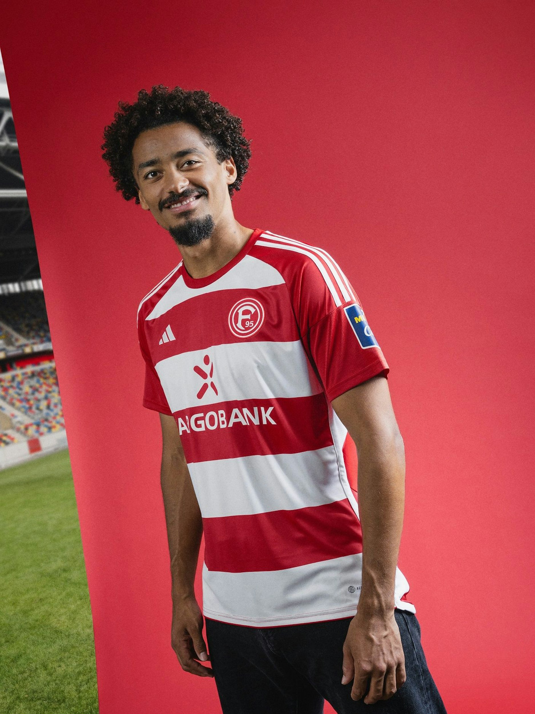 Emmanuel Iyoha präsentiert das neue Heim-Trikot von Fortuna Düsseldorf.