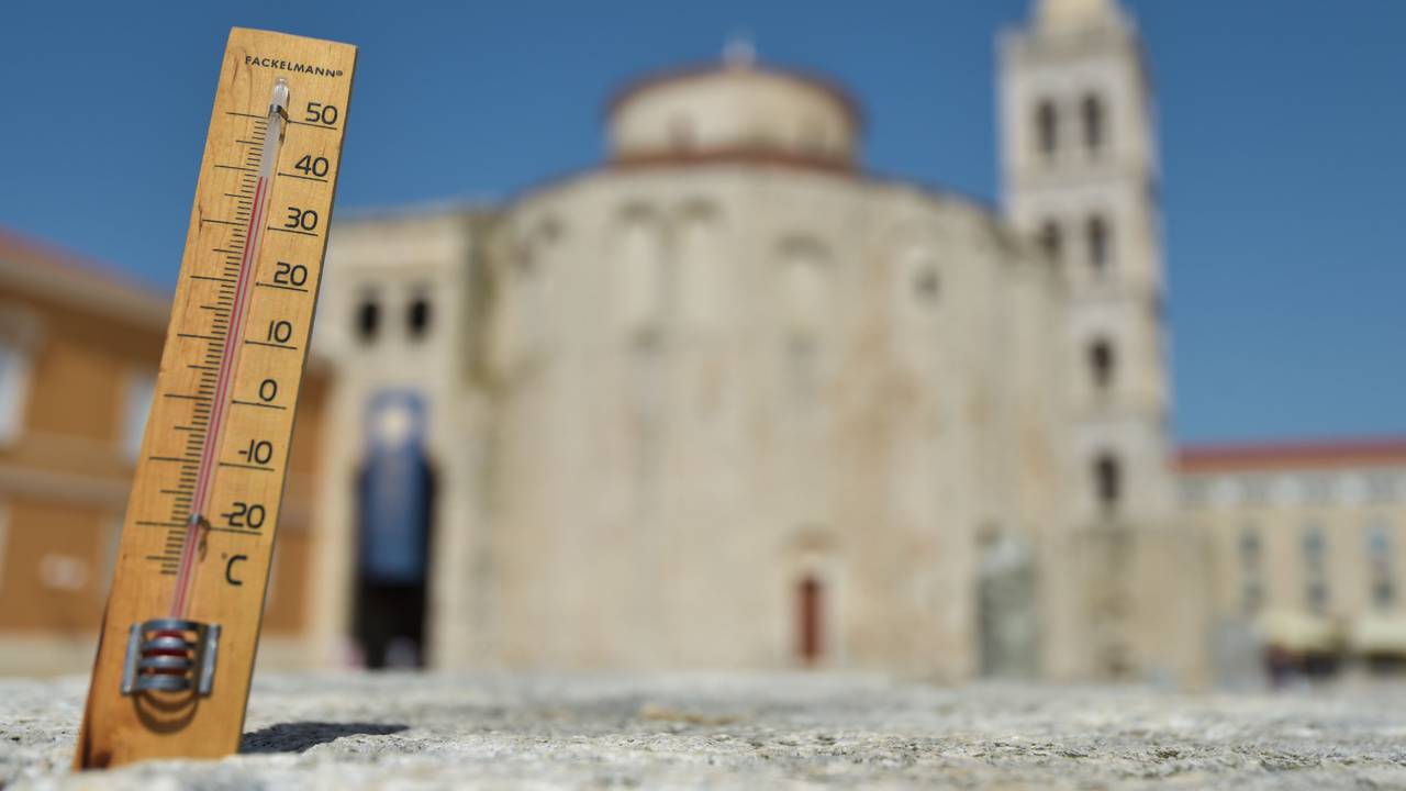 Ein Thermometer zeigt vor der Kulisse der romanischen Kathedrale St. Anastasia die Temperatur von 39 Grad Celsius an.