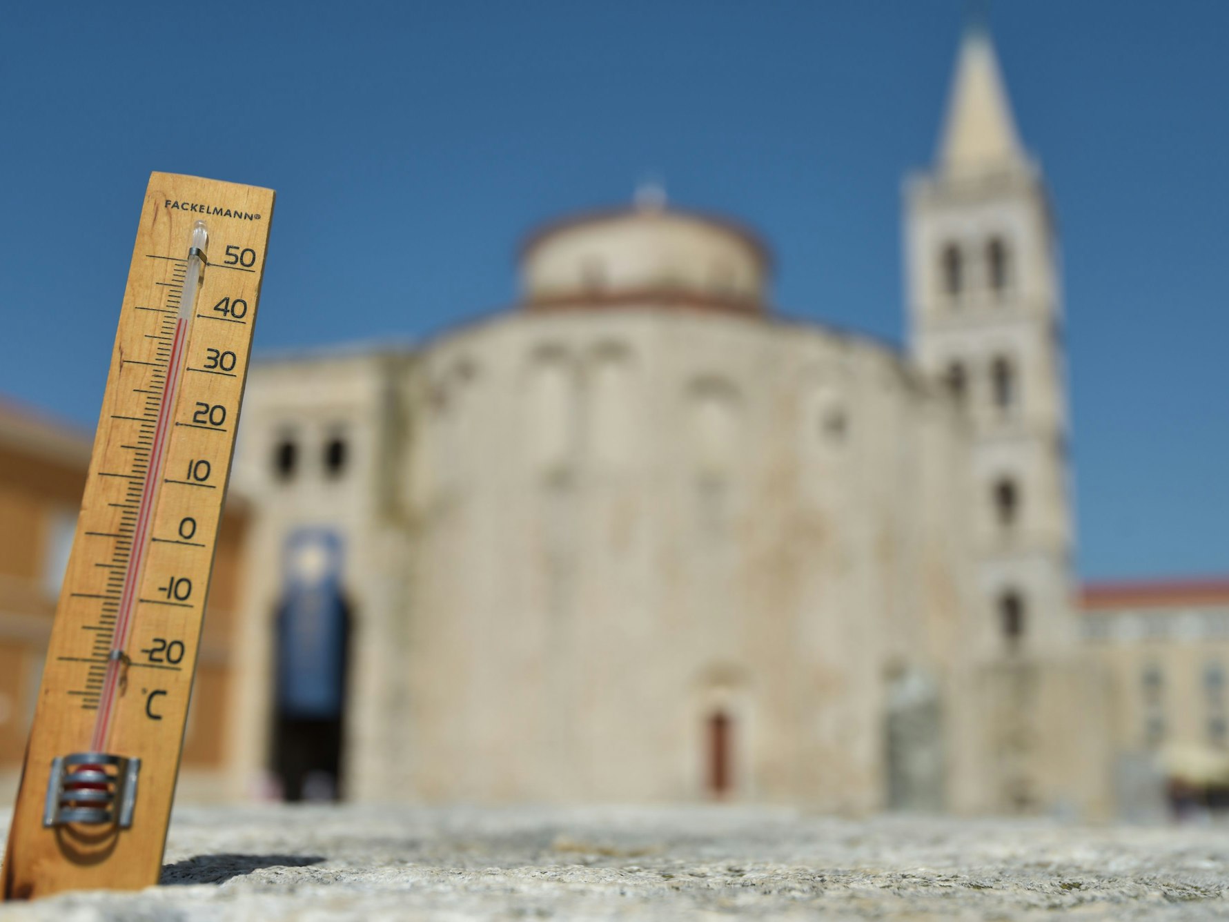 Ein Thermometer zeigt vor der Kulisse der romanischen Kathedrale St. Anastasia die Temperatur von 39 Grad Celsius an.