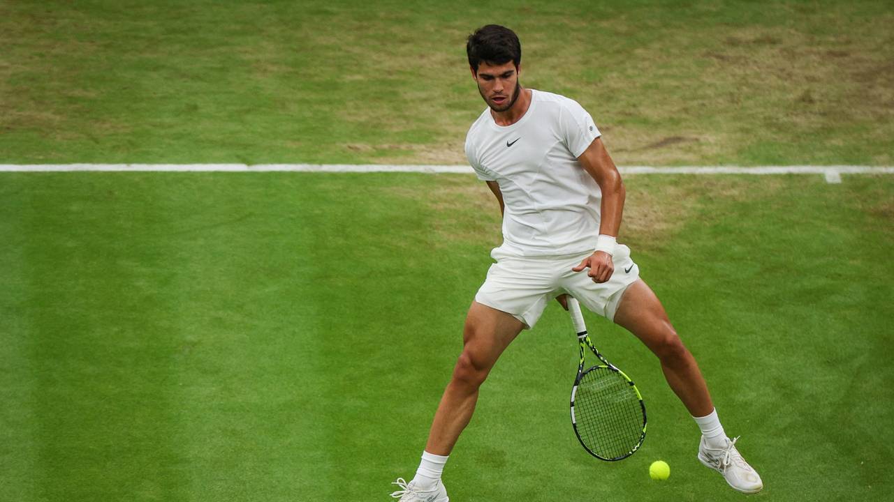 Carlos Alcaraz spielt den Ball mit seinem Schläger durch seine Beine.