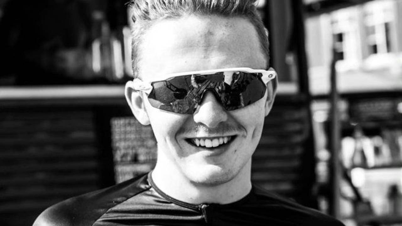 Connor Lambert lacht auf einem Schwarz-Weiß-Bild mit Sonnenbrille in die Kamera.