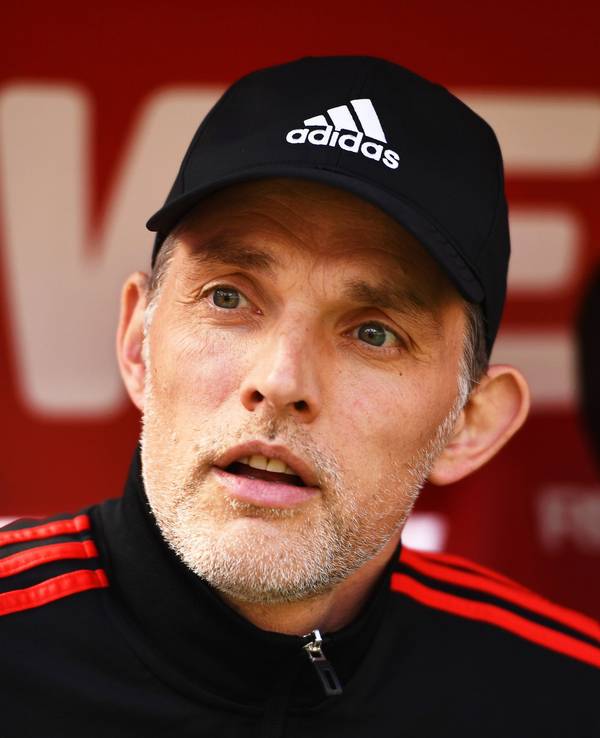 Thomas Tuchel sitzt auf er Bank. Er trägt eine schwarze Kappe.