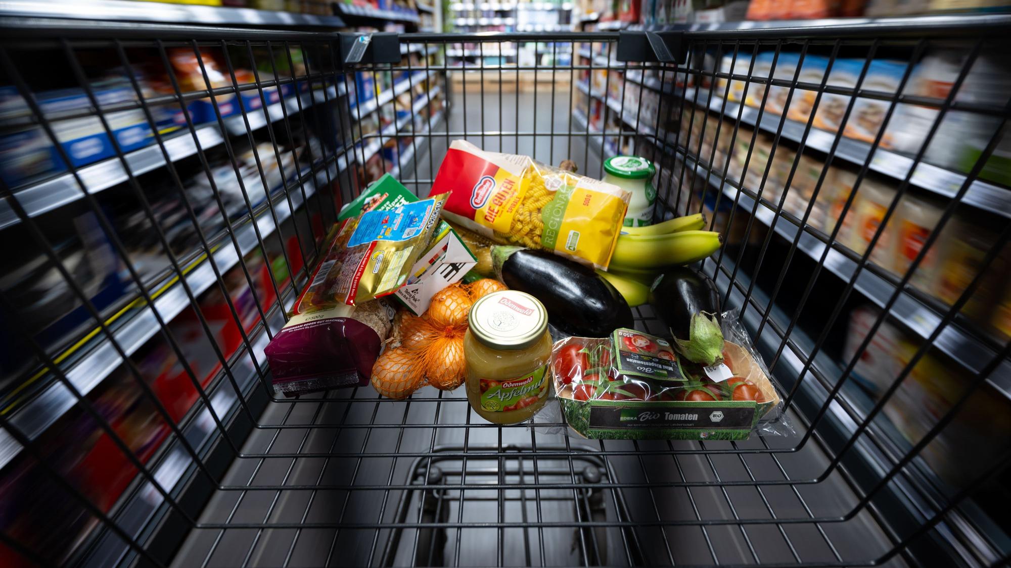 Verschiedene Lebensmittel liegen in einem Supermarkt in einem Einkaufswagen