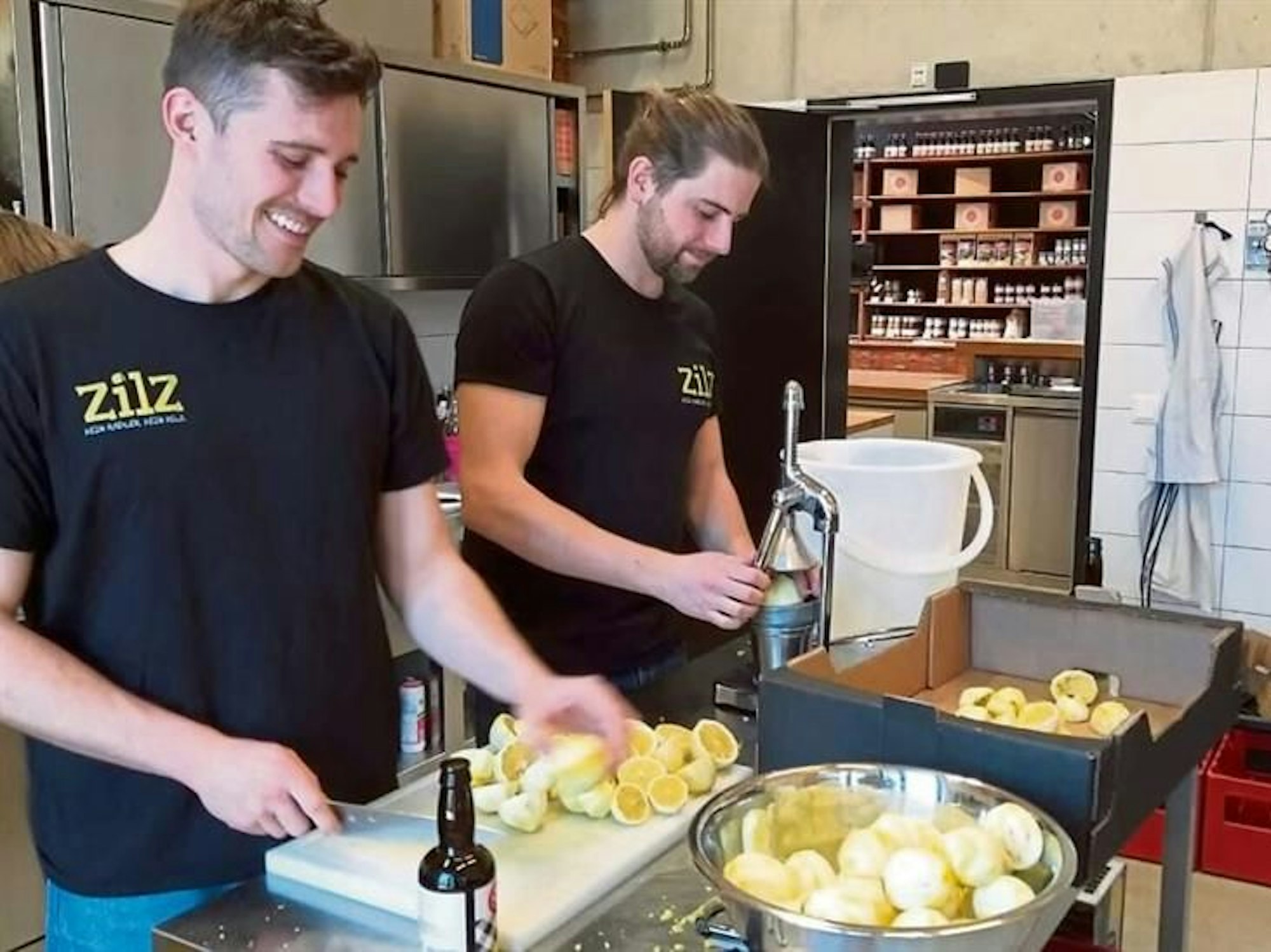Die beiden Brauer Lorenz Schareim-van der Zander (l.) und Felix Albrecht stehen in der Küche und pressen Zitronen.