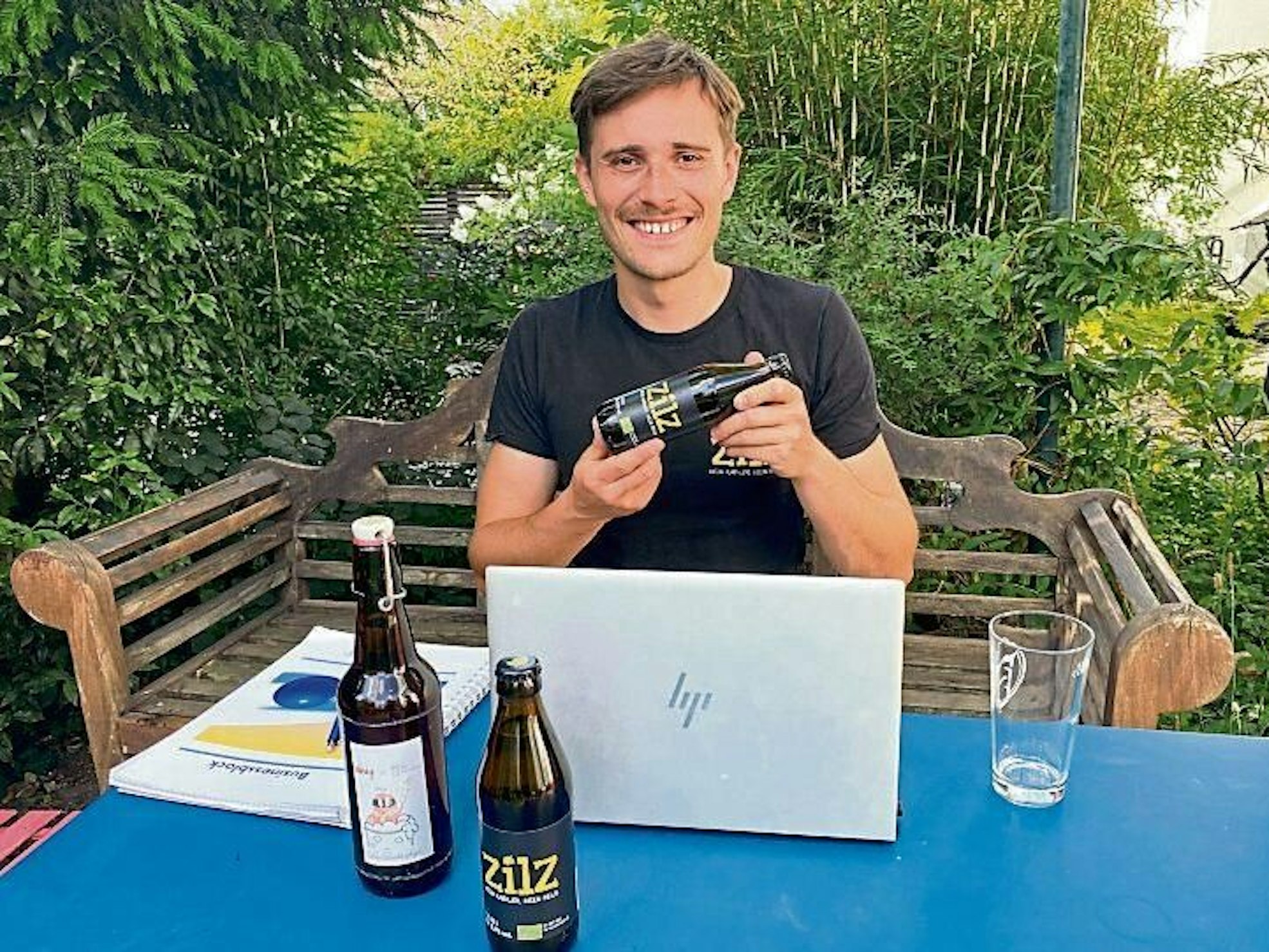 Bierbrauer Lorenz Schareim-van der Zander hält sein eigenes Bier „Zilz“ in die Kamera.