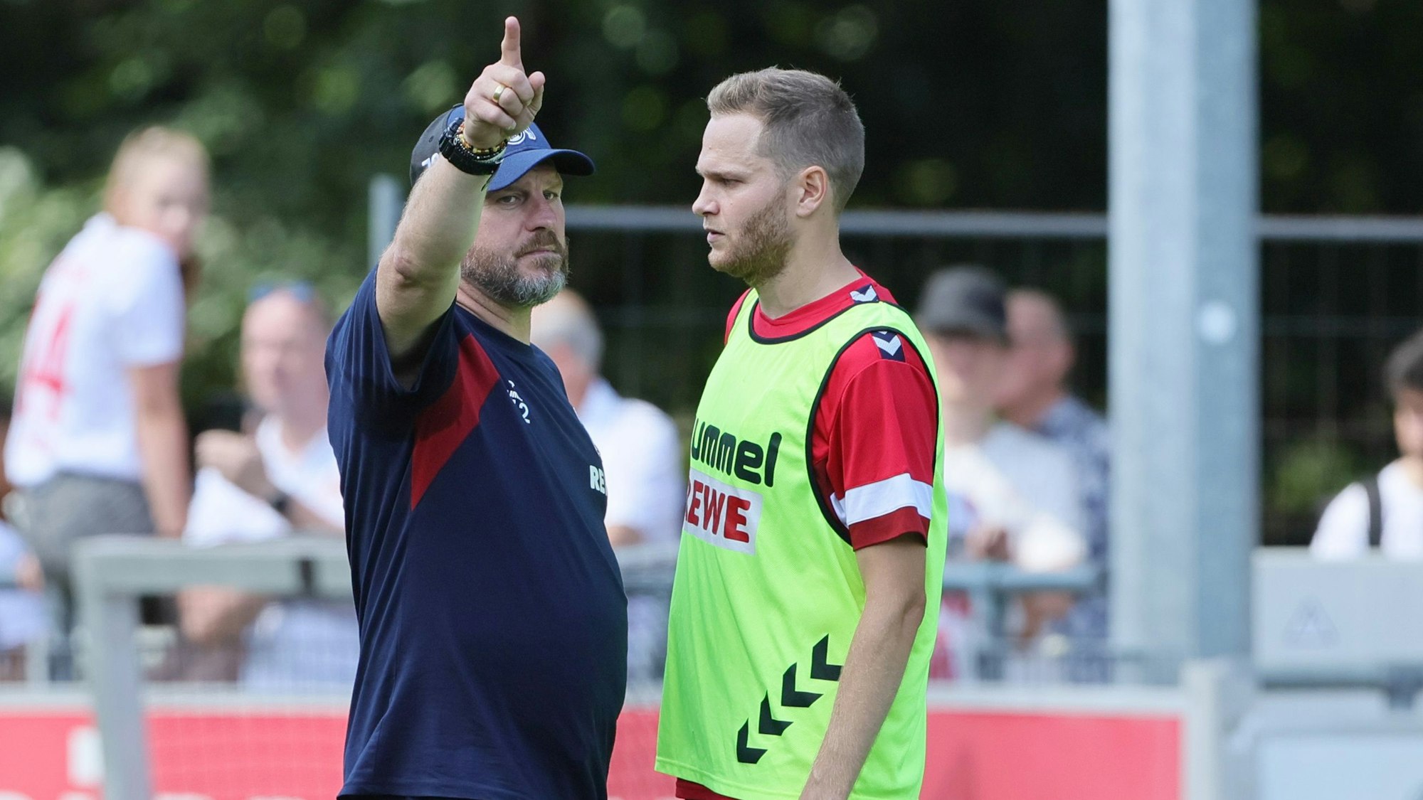 Steffen Baumgart zeigt Benno Schmitz etwas an.