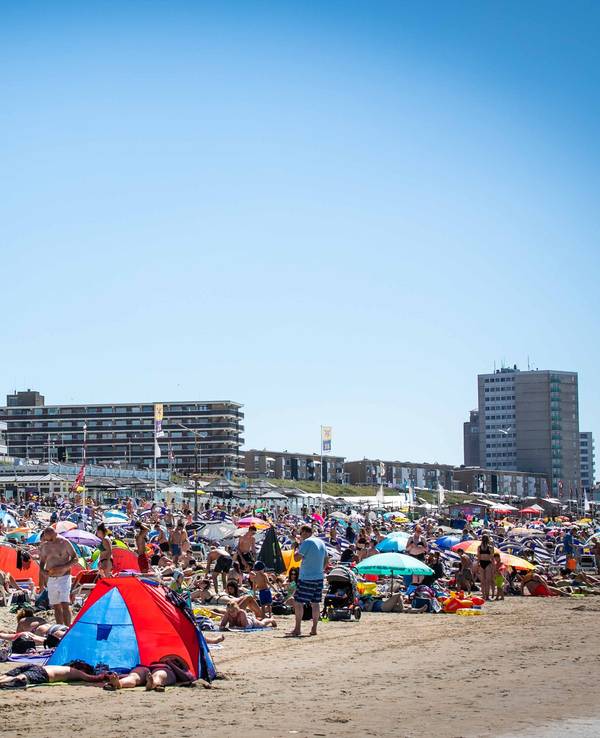 Zahlreiche Menschen genießen in unserem Archivbild (2020) das heiße Wetter am Strand nahe dem Bahnhof Zandvoort.