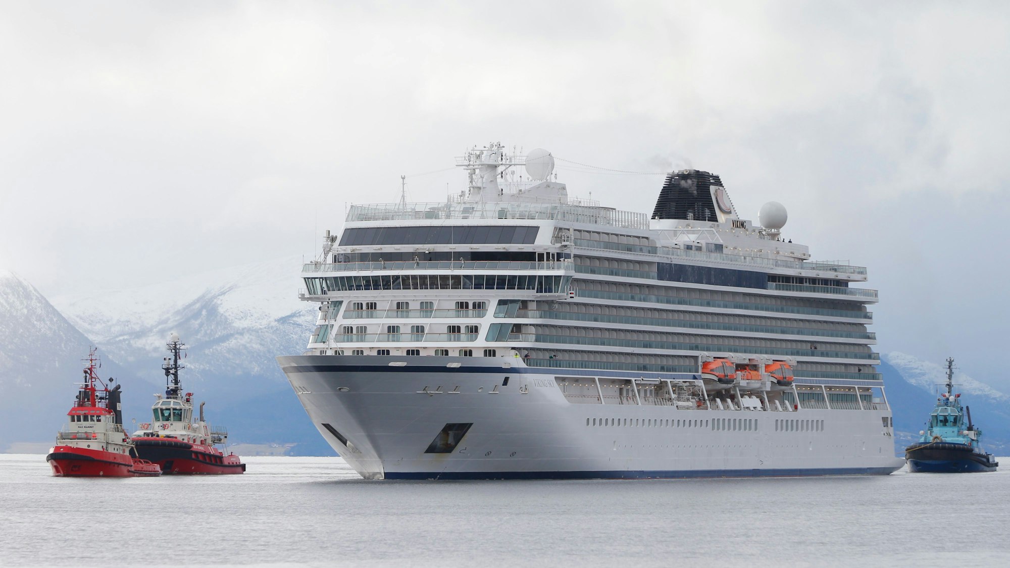 Das Kreuzfahrtschiff „Viking Sky“ fährt über das Meer. Im Hintergrund sind Berge zu sehen.