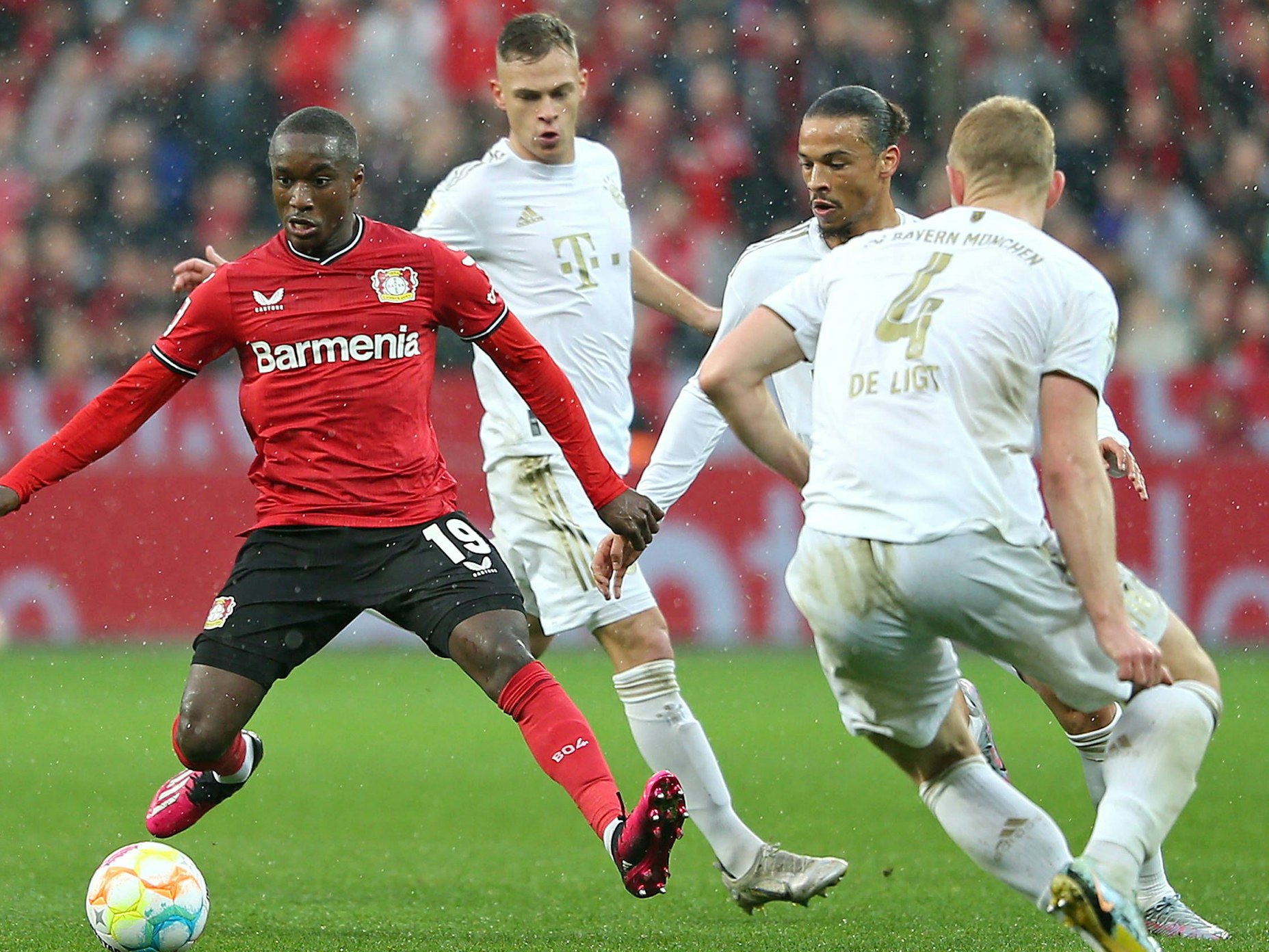 Moussa Diaby hat den Ball am Fuß, Bayern-Spieler umstellen ihn.