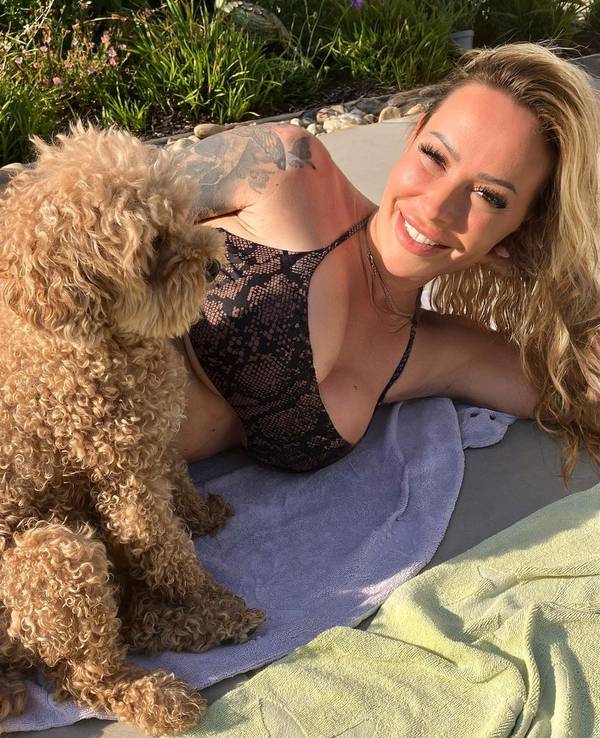 Cora Schumacher und ein Hund liegen gemeinsam auf einem Handtuch.