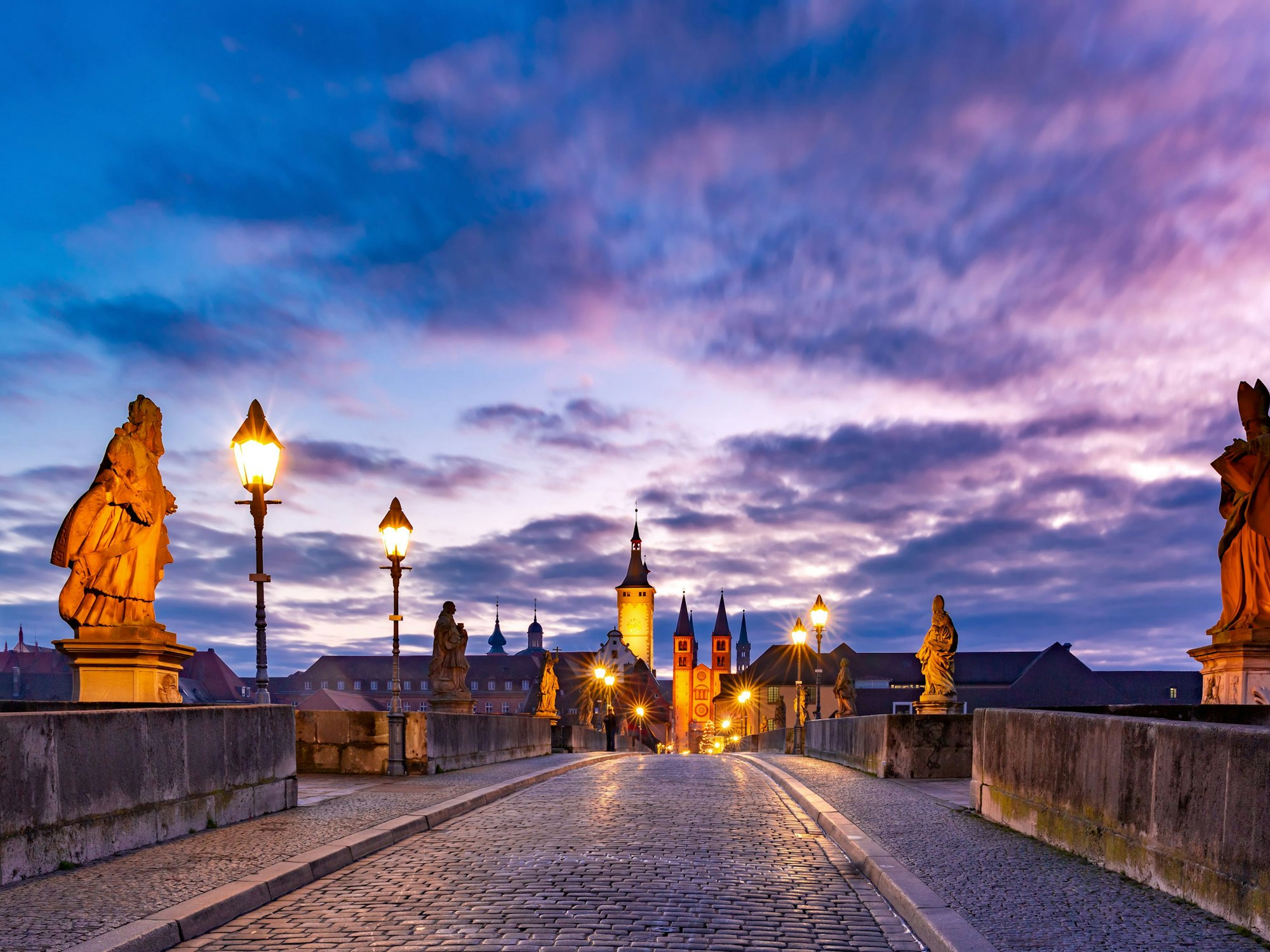 Die alte Mainbrücke in Würzburg ist komplett leer bei der Dämmerung.